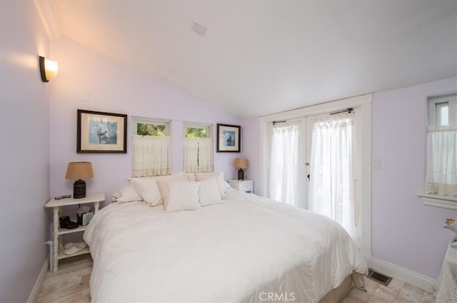 bedroom with light wood-type flooring, lofted ceiling, and french doors