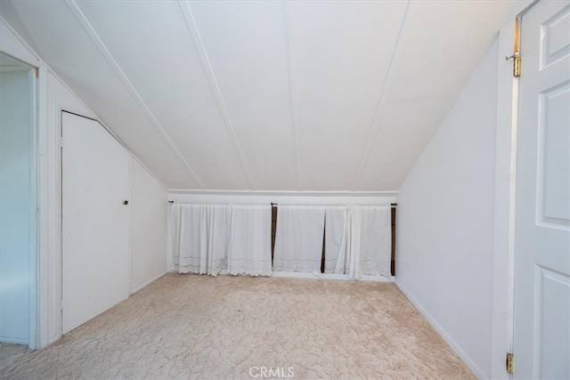 additional living space with vaulted ceiling and light carpet