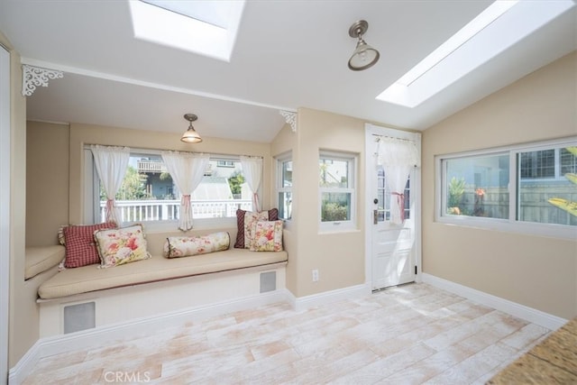 living area with vaulted ceiling with skylight and a wealth of natural light