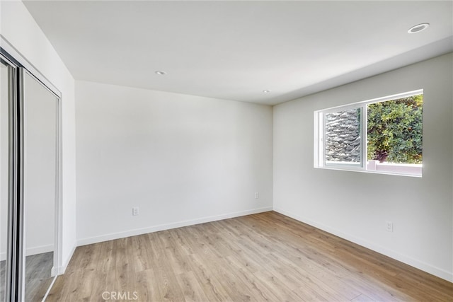 unfurnished bedroom with a closet and light hardwood / wood-style floors