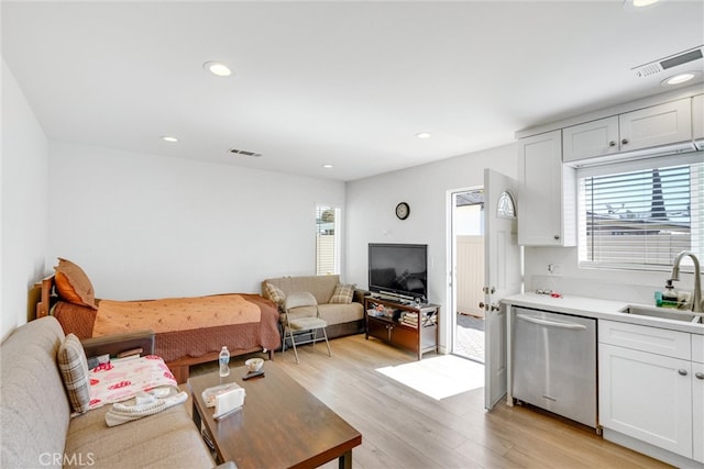 living room with sink and light hardwood / wood-style flooring