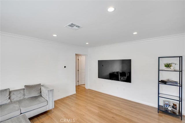 living room featuring crown molding and light hardwood / wood-style floors