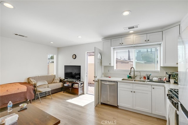 kitchen featuring appliances with stainless steel finishes, light hardwood / wood-style floors, sink, and plenty of natural light