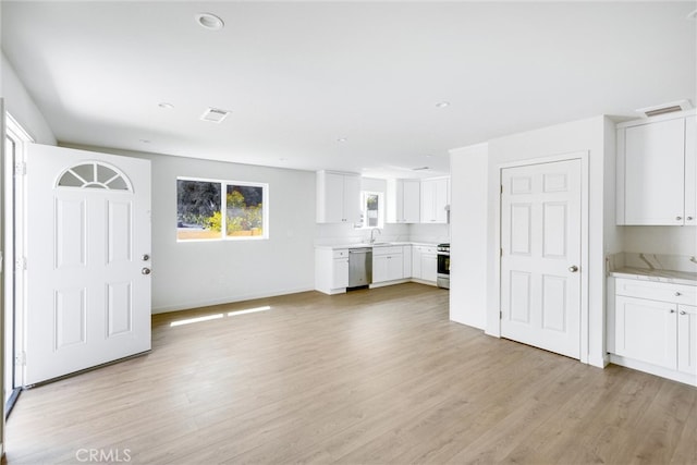 unfurnished living room featuring light wood-type flooring and sink