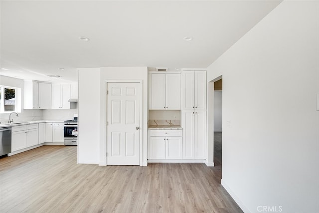 kitchen featuring light hardwood / wood-style flooring, white cabinetry, appliances with stainless steel finishes, and sink