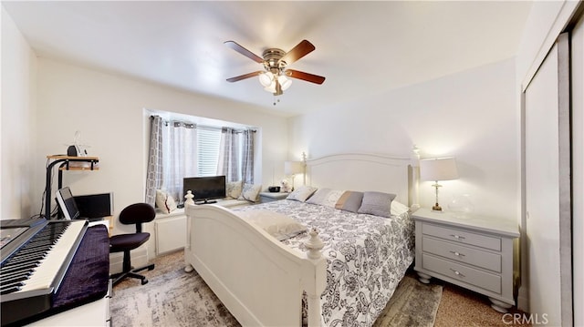 bedroom featuring light carpet, ceiling fan, and a closet