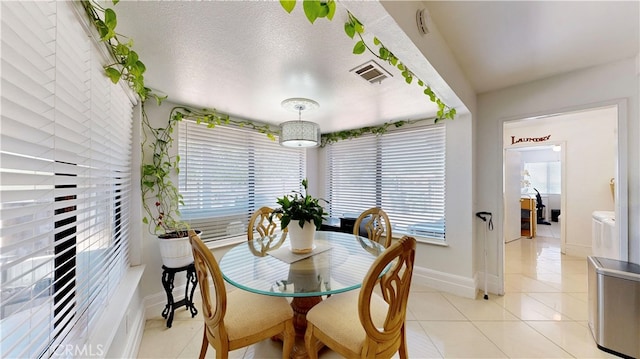 tiled dining area with a textured ceiling