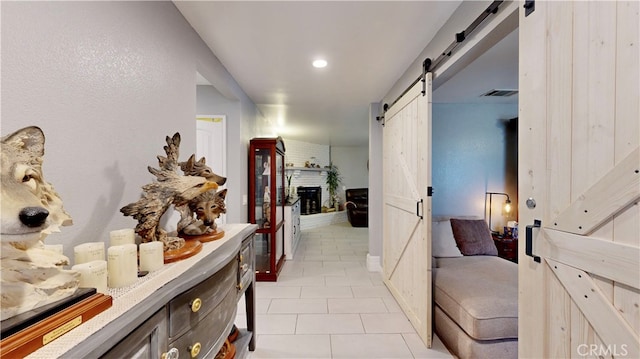 hallway with light tile patterned flooring and a barn door