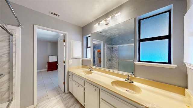 bathroom with a shower with door and vanity