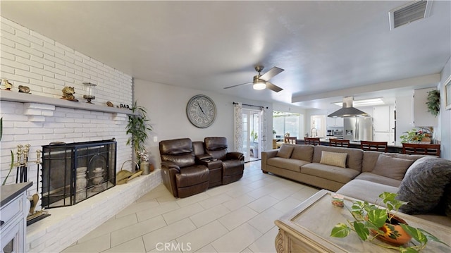 living room with ceiling fan and a fireplace