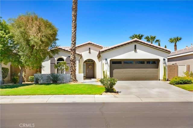 mediterranean / spanish home with a garage and a front lawn