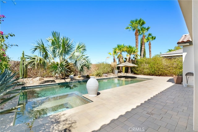 view of pool with a patio and an in ground hot tub