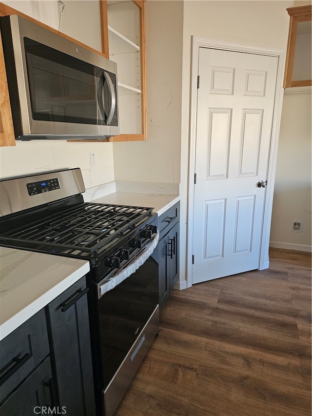 kitchen featuring light stone countertops, stainless steel appliances, and dark wood-type flooring