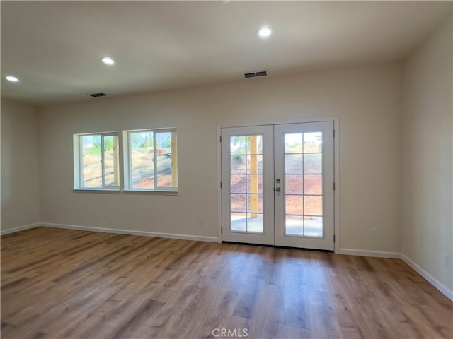 doorway to outside featuring light wood-type flooring, french doors, and a wealth of natural light