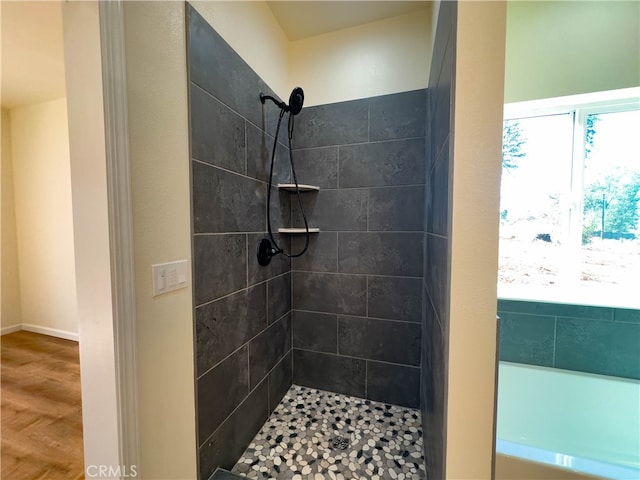 bathroom featuring wood-type flooring and tiled shower