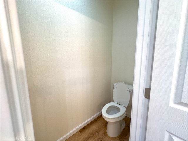 bathroom with hardwood / wood-style flooring and toilet