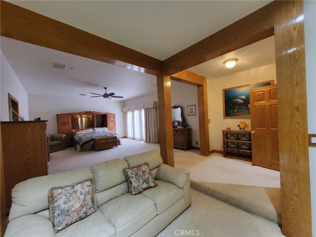 bedroom with ceiling fan, beam ceiling, and light carpet