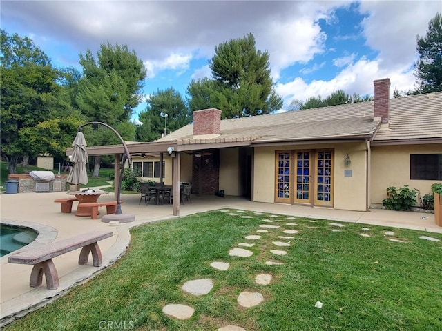 back of house featuring a patio, ceiling fan, and a lawn