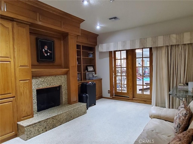 carpeted living room featuring a high end fireplace