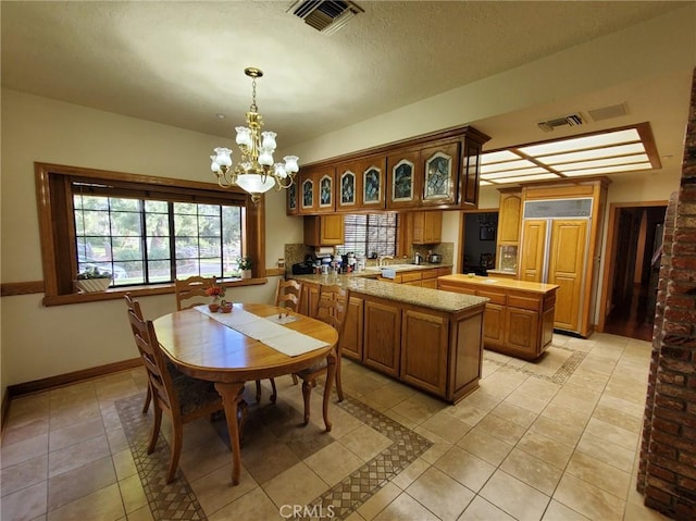 dining room with a notable chandelier, light tile patterned floors, sink, and a wealth of natural light