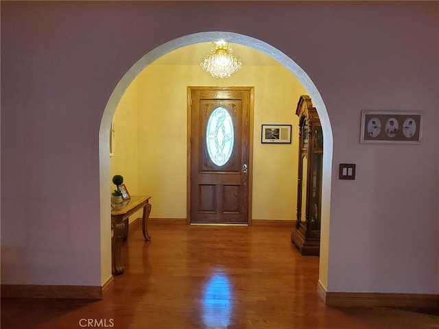 foyer featuring wood-type flooring and an inviting chandelier