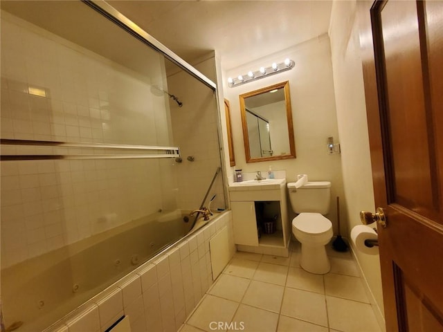 full bathroom featuring tile patterned flooring, toilet, tiled shower / bath, and sink