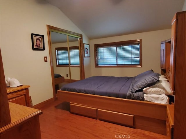 carpeted bedroom with a closet and lofted ceiling