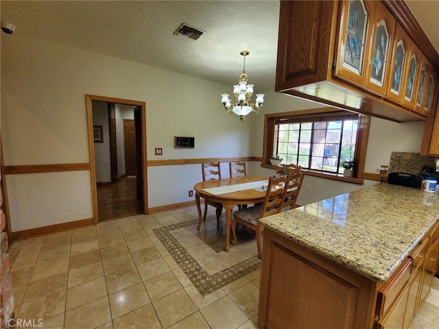 dining room with light tile patterned flooring, a chandelier, and a textured ceiling