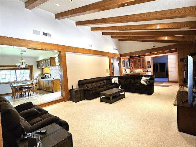 carpeted living room featuring a notable chandelier, vaulted ceiling with beams, and bar area