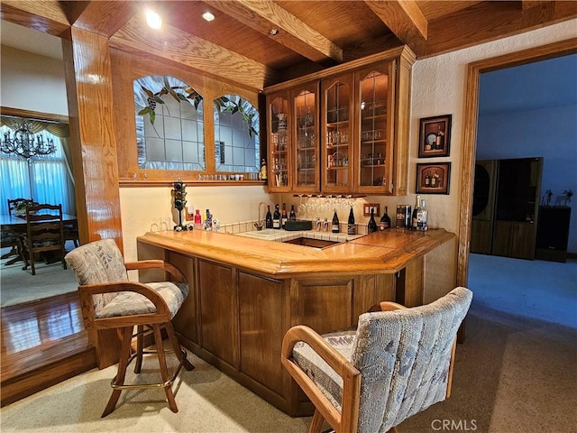 bar with wooden ceiling, sink, black stovetop, beamed ceiling, and light colored carpet