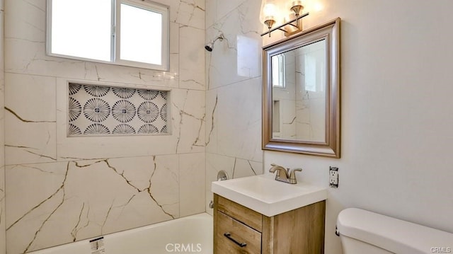 full bathroom featuring vanity, tiled shower / bath combo, and toilet