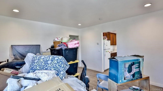 bedroom with light wood-type flooring and white refrigerator