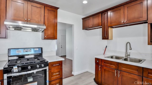 kitchen featuring light wood-type flooring, sink, and gas stove