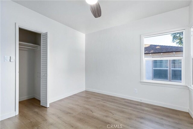 unfurnished bedroom featuring light hardwood / wood-style floors, a closet, and ceiling fan