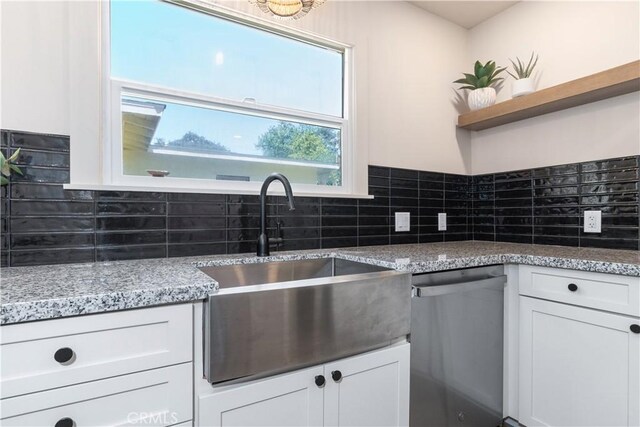 kitchen featuring white cabinetry, dishwasher, sink, and decorative backsplash