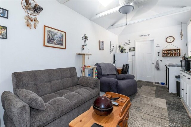 living room with dark colored carpet, vaulted ceiling with beams, and ceiling fan