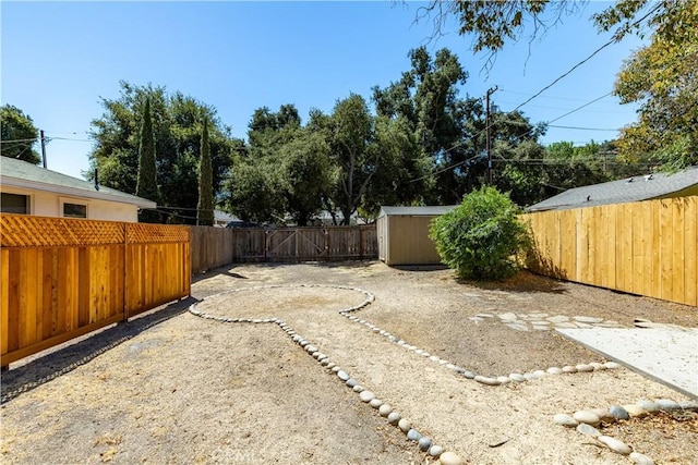 view of yard with a fenced backyard, a storage unit, and an outdoor structure