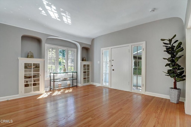 foyer entrance featuring light wood-type flooring and baseboards