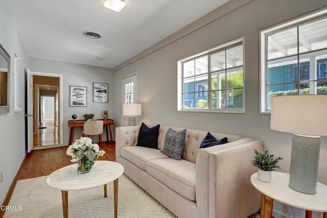 living area featuring visible vents and wood finished floors