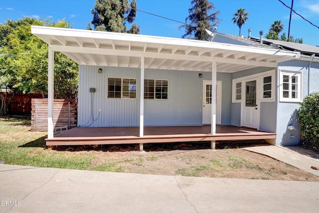 exterior space featuring covered porch and fence