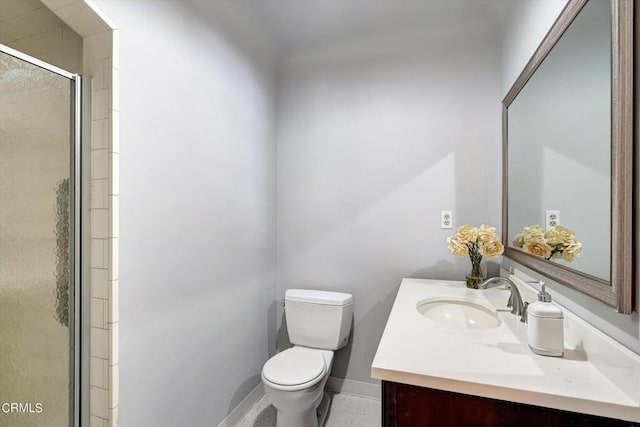 bathroom with a stall shower, toilet, vanity, and baseboards