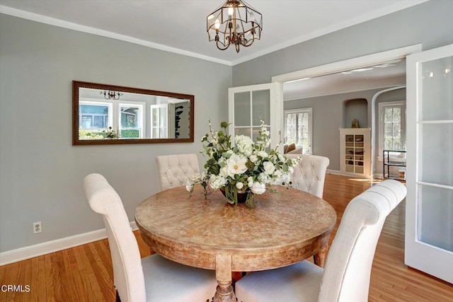 dining room with a chandelier, baseboards, wood finished floors, and ornamental molding