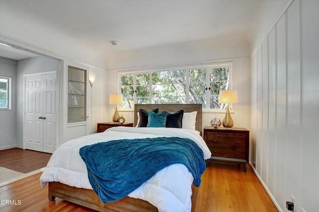 bedroom with wood finished floors and a closet