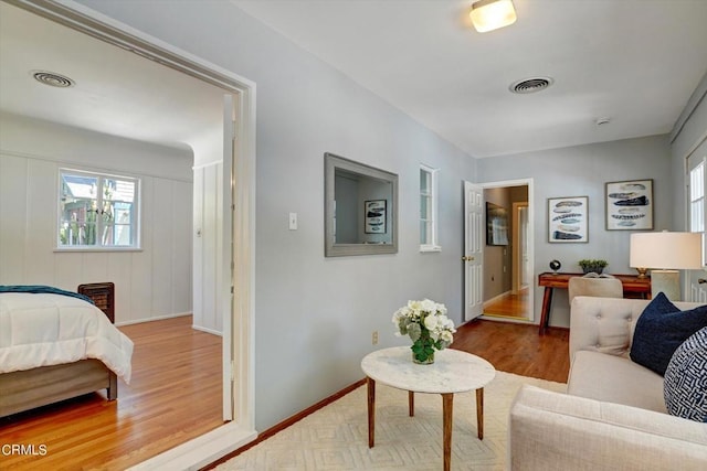 living room with visible vents, baseboards, and wood finished floors