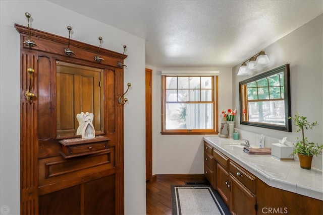 bathroom featuring vanity, hardwood / wood-style flooring, and a textured ceiling