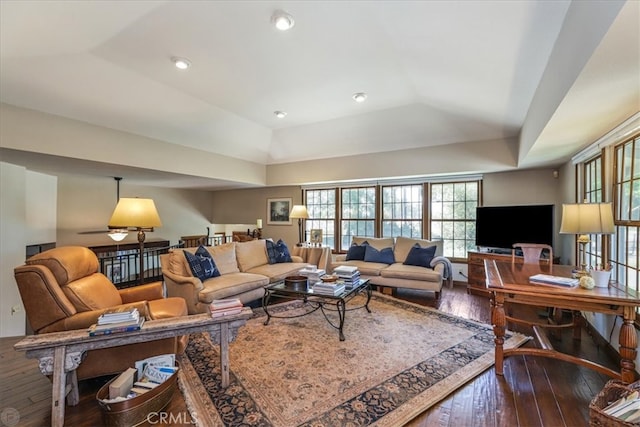 living room with wood-type flooring and a tray ceiling