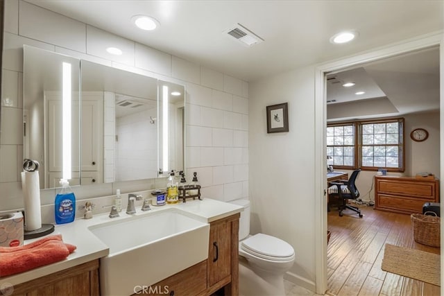 bathroom featuring vanity, toilet, and hardwood / wood-style flooring