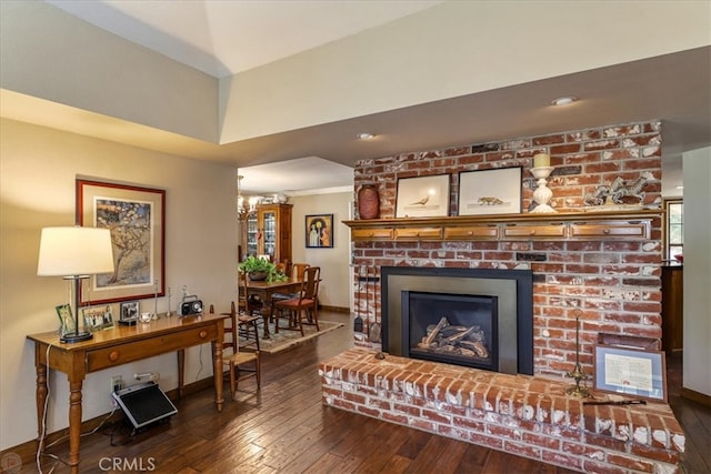 living room with a fireplace and dark wood-type flooring