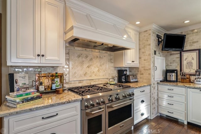 kitchen featuring double oven range, custom range hood, dark wood-type flooring, and white cabinets