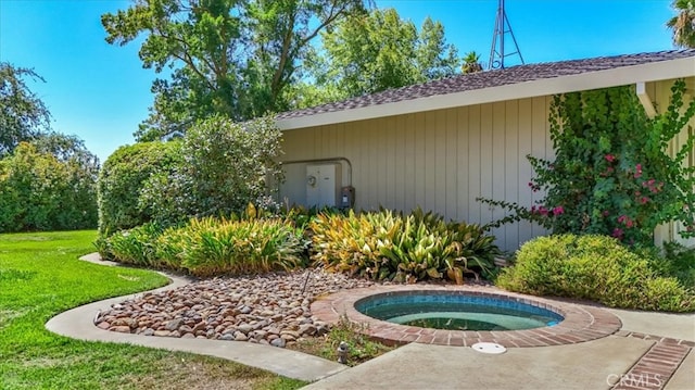 exterior space with a lawn and an in ground hot tub